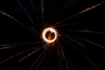 Long exposure shot of round light sparks in the dark