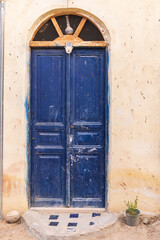 A blue painted door on a building in the village of Faiyum.