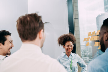 Fototapeta premium Groups of business people diverse brainstorming presentation ideas using label color sticky on glass wall together in the office, planning strategy new marketing projects, and teamwork concepts.