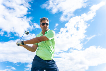Fototapeta na wymiar Male golf player on professional golf course hitting the ball with the stick driver