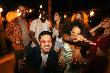 Friends at the rooftop party at night. - obrazy, fototapety, plakaty