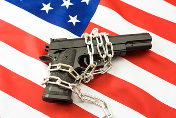Gun over American patriotic flag, firearms restriction debate.