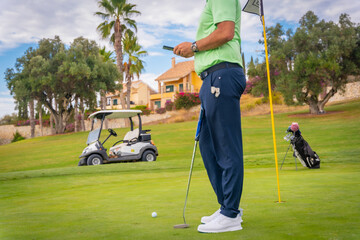 Obraz premium Businessman playing golf and writing an email with the phone from the club