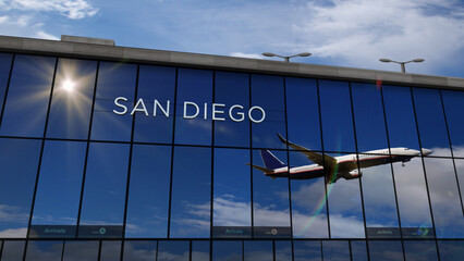 Airplane landing at San Diego California, USA airport mirrored in terminal - obrazy, fototapety, plakaty