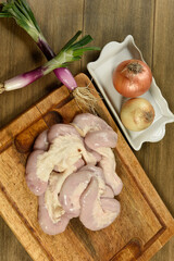 Cow bowels presented on a wooden board with ingredients, ready to grill