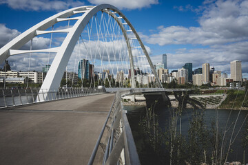 Close-up of suspension bridge during the day with Edmonton, Alberta, Canada skyline in background