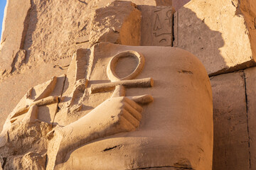 Ruined statue holding two ankhs at the Karnak Temple complex in Luxor.