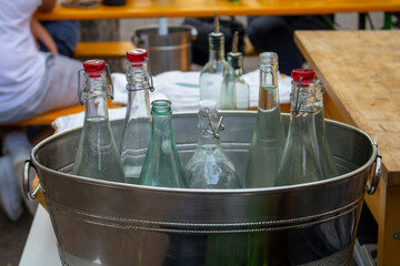 long neck water bottles in a metal stainless steel bowl with ice cubes