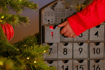 advent calendar.santa claus in hand on christmas advent calendar background.child hand in a sweater...