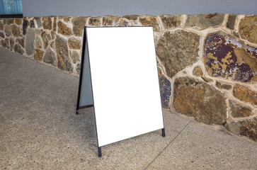 Blank white mockup template background texture of an advertising board panel placed against a rock...