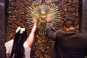 a couple holding the sacred heart in a church