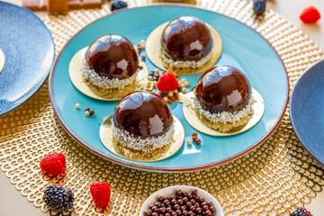  cupcake. Chocolate cake with raspberry set on a blue plate and chocolate decor on a beige table.Berry dessert.Delicate airy cake souffle.Appetizing cupcakes and pastries.Choux pastry. 