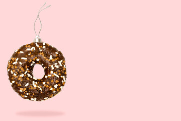 Christmas bauble ball toy made of chocolate glazed doughnut donut dessert on pink background
