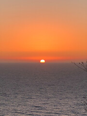 Puesta de sol al atardecer en tonos naranjas del sol y azules del mar