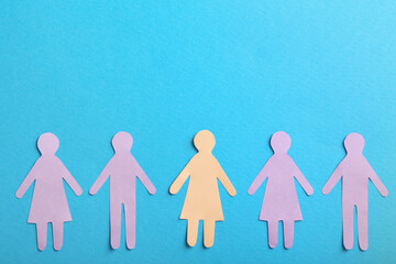Many different paper human figures on light blue background, flat lay with space for text....