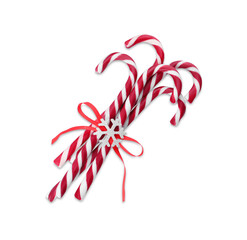 Sweet Christmas candy canes with red bow and snowflake on white background, top view