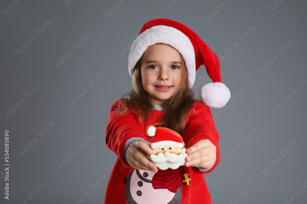 Canvas Prints Cute little girl with Christmas gingerbread cookie on grey background