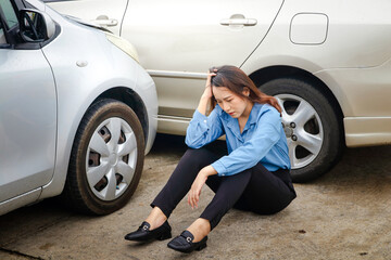 stressed asian woman She sat on the concrete road. A car crashes on the road during rush hour. The concept of transportation. car insurance