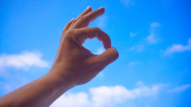 Male fist isolated on blue sky background. Asian hand make sign OK. Counting, brave, masculinity concept