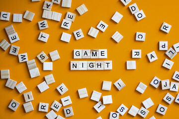 Letter tiles board game on orange background with words Game Night