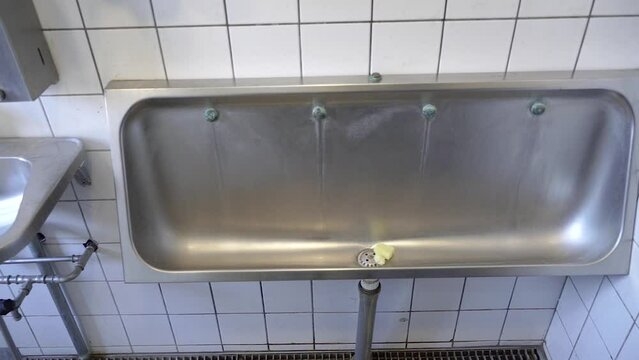 Urinal. Metal urinal in a public toilet.