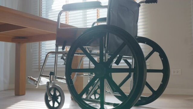 Empty Wheelchair in living room with warm sun light. Feeling Lonely, Sadness, hope concept.