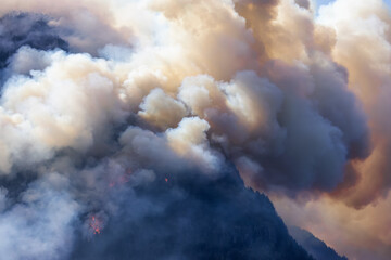 BC Forest Fire and Smoke over the mountain near Hope during a hot sunny summer day. British Columbia, Canada. Wildfire natural disaster