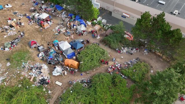 Overhead drone shot of a homeless camp in Washington State with trash spread across the ground.