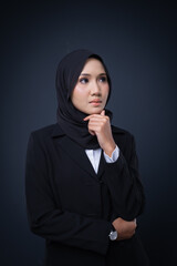 Portrait of an attractive Muslim woman wearing business attire and hijab with a corporate pose isolated on grey background. For image cut-out for technology, business or finance.