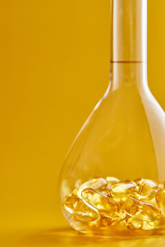 Omega-3 fatty acid capsules on a blue background in a flask. The concept of medicine and healthy living. Vertical photo.