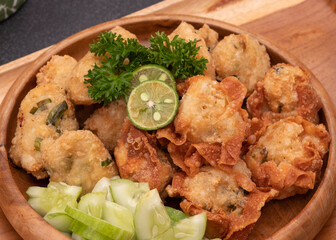 Delicious batagor or meatballs tofu is one of the popular indonesian traditional foods. Made from fish, tofu and peanut sauce. on wooden background. Top View, Close Up