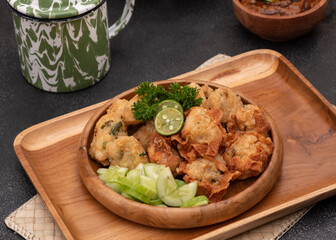Delicious batagor or meatballs tofu is one of the popular indonesian traditional foods. Made from fish, tofu and peanut sauce. on wooden background. Top View, Close Up