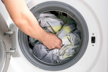 Woman's hand Pick up clothes Washing machine. Clean and Healthy Concepts.