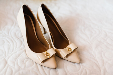 Beige patent leather shoes on a white background.