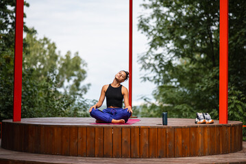 Young woman is practising yoga sitting in the lotus position