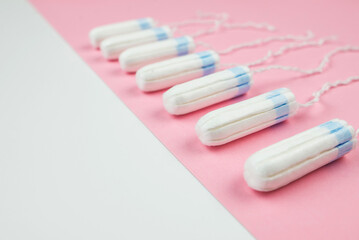 tampons on a pink and white background with copy space.