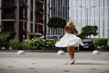 Beautiful pretty woman in white dress walking at city street