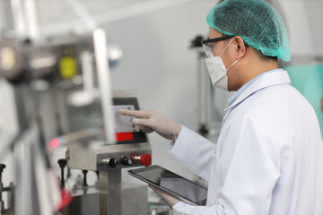Worker in personal protective equipment or PPE inspecting quality of mask and medical face mask...