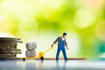 Miniature people, man pulling cargo with stack coins using for logistic, business and financial concept