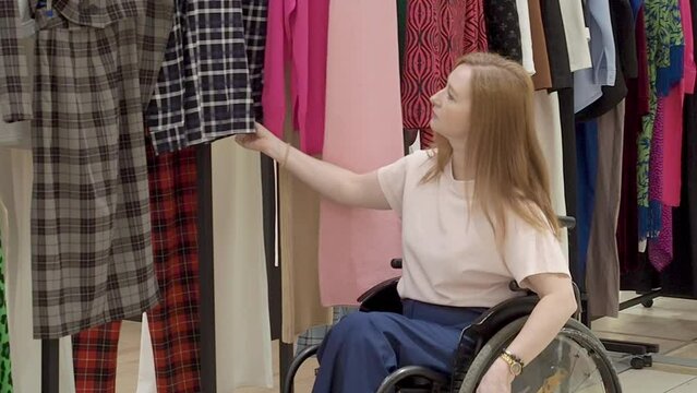 adult woman who uses a wheelchair chooses clothes in a store