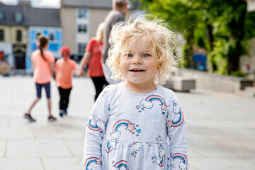 Cute toddler girl with city on background. Happy healthy child and Family and small children...