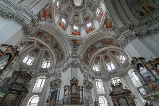 Inside undershoot of a dome of Salzburg Cathedral with paintings and golden frames