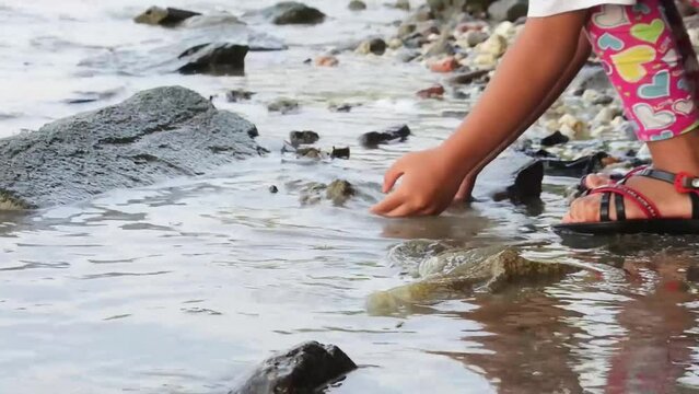 little girl washing hands on the beach. HD videos. focus on the feet and hand.
