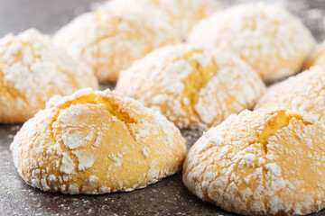 Close-up of cracked lemon biscuits sprinkled with powdered sugar close-up on the table. horizontal