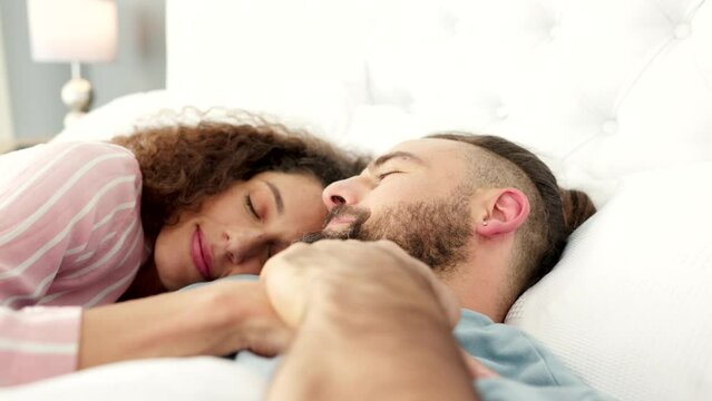 Sleep, love and relax with a couple in a bed of the bedroom of their home together on a weekend morning. Sleeping, happy and smile with a man and woman resting, lying and kissing in their house