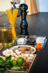 Focused on Shrimp in among of ingredients, lime, mushroom, shallot, lemon grass, spring onion, chilli, tobiko, bergamot, cheese and spaghetti meal cooking.