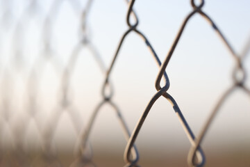 Fototapeta premium Closeup of chain link fence. Mesh netting on gray background
