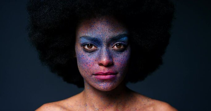 Creative makeup and portrait of black woman in studio with afro and serious face with background for mockup. Thinking, pensive and focused African American with color cosmetic splatter beauty art.
