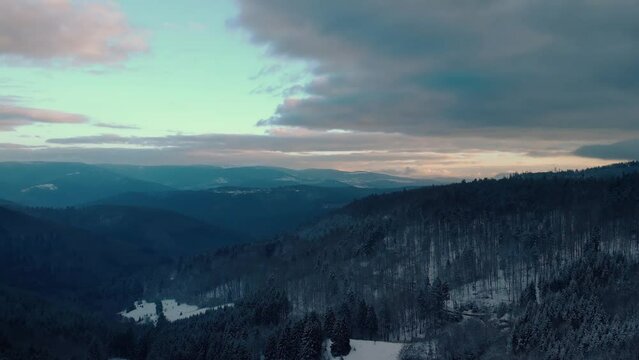 Drone shot dolly sideways above vosgians snowy moutains next Mont Donon during a peacefull sunset