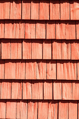 Red wood shingle on a sunny house wall